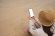 © Farknot Architect - Top view mockup image of a woman holding mobile phone with blank desktop screen on the beach