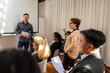 © Rawpixel.com - A diverse group in a meeting room, with a man presenting and others listening.