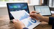 © Alif - Analyst reviewing financial growth reports with laptop in modern office