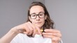 © Aliaksandr - Young woman in glasses and white t shirt sharpening a yellow pencil using a small manual sharpener, focusing on the task with concentration in an indoor setting