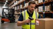 © Rhony - Male worker uses a handheld barcode scanner to scan a label on a cardboard box in a warehouse.