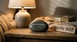 © athirah - Stone with wellbeing message beside lamp and books