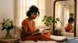 © Medy - Young woman sitting on bed writing in a journal at home