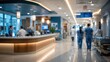 © Paras - defocused perspective of a busy hospital hallway featuring medical personnel in scrubs near a modern reception station, bright clinical interior.