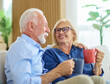 © Lumos sp - Portrait of a happy senior couple embracing talking and drinking coffee or tea at home