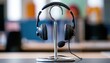 © AndyAziz - Black headset with microphone on a metallic stand in an office environment