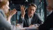 © Sunijsa - Man gestures emphatically during tense business discussion