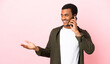© luismolinero - African American man on copyspace pink background keeping a conversation with the mobile phone with someone