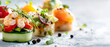 © Anoo - Buffet appetizers are arranged on a white surface with shrimp canapes, salad, and a vibrant tart. Space for text is on the left for catering purposes