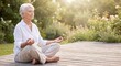 © mtmakos - An elderly woman sits cross-legged on a wooden deck in a sunlit garden, meditating peacefully.