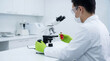 © Rendara Studio - Research scientist evaluating a biological sample beside a laboratory microscope