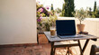 © Edward.S - Laptop on a wooden patio table with iced coffee outdoors