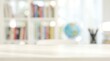 © CuteBee - Bright home office workspace with empty wooden desk and blurred bookshelf background for educational and professional interior design concepts