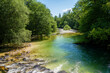 © JairoMZ - Crystal clear river in Bohinj Slovenia surrounded by lush forest representing pristine nature and sustainable ecotourism destinations