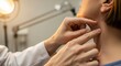 © SashaMagic - Doctor examines patient's neck for swollen lymph nodes, focusing on health and care in a warm, clinical setting.