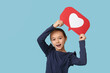 © Pixel-Shot - Little girl with heart like icon on blue background