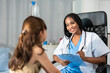 © Kawee - African pediatrician examine young girl during medical checkup in hospital.