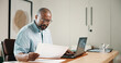 © peopleimages.com - Laptop, finance and black man with documents in home for budget planning, audit or expenses. Mature person, accounting or paperwork with computer for financial assessment, review or report in house