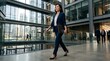 © Rena - Professional woman in suit walking in modern corporate office lobby