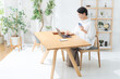 © metamorworks - 部屋でスマホとノートパソコンを使う女性。アプリ、フリーランス、仕事、ライフスタイル、DX