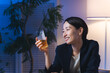 © metamorworks - 暗い部屋でお酒を飲む女性。ビール、ウイスキー、飲み会、居酒屋、バー、スナック、宅飲み