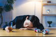 © metamorworks - 暗い部屋で酔い潰れる女性。お酒、ショック、がっかり、落ち込む、やけ酒、酔う、アルコール、居酒屋