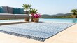 © Pixim Stock - Stylish blue and white patterned outdoor rug with fringe rests on tiled patio beside swimming pool and lounge sofa with tropical plants on sunny day.