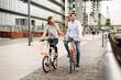 © Westend61 - Smiling couple riding bicycle in the city
