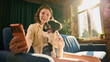 © master1305 - Young woman taking cheerful selfie with small dog in cozy home. Concept of pet social media, influencer content, mobile communication, emotional bonding and pet brand campaigns.