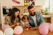 © La Famiglia - Family laughing, playing with balloons celebrating daughter's birthday