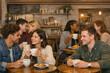 © Alexandr Efimov - Group of happy people enjoying coffee and pastries at a coffee shop.