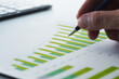 © tadamichi - Business report and financial data analysis. Performance analytics with statistical graphs and charts. Businessman reviewing plan and making strategy on desk.