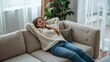 © Magdalena Wojaczek - Young woman relaxing on comfortable sofa in bright modern apartment