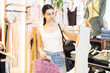 © JackF - Young woman buyer choosing summer blouse in clothing store