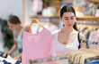 © JackF - Young female shopper choosing blouse in clothing store
