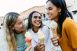 © Xavier Lorenzo - Smiling multiracial friends holding ice cream cones. Young women enjoying friendship and travel during summer vacation. Lifestyle and friendship concept.