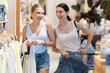 © JackF - Two sisters girl chooses something in clothing store. Customer inspects stores assortment, looks closely at summer clothes. .