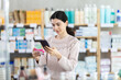 © JackF - Young woman buyer scanning qr code for box of paracetamol tablets in pharmacy
