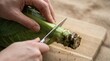 © SimpleDesignStudio - Person cutting cabbage stem on wooden board for healthy meal preparation in kitchen