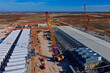 © WILL PHOTOGRAPHY - Aerial view of data center construction with BESS batteries and red cranes