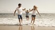 © Sara - Joyful family with young child running through shallow ocean waves on a sunny beach day