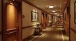 © Ma - Luxurious carpeted hotel hallway with wooden doors and lighting.