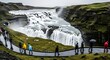 © Purname - Powerful Tiered Waterfall Flowing Through Green Rugged Canyon with Tourists on Rainy Path