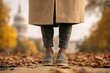 © Hidayat - Person in casual attire walks on path covered in autumn leaves, building in background