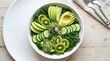 © bambang - Fresh green salad bowl with sliced avocado cucumber kiwi and apple