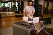 © Svitlana - Older man using fitness machine with younger assistant in gym