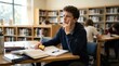 © sambath - A young man sitting at a desk in a library, engrossed in studying.