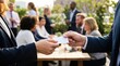 © MT - Professional business people exchanging a blank white business card at an outdoor corporate networking event for career development