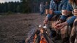 © MT - Friends roasting marshmallows over a campfire at dusk, young adults enjoying a cozy autumn evening outdoors with hot drinks and blankets