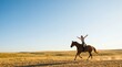 © MT - Young woman riding horse with arms outstretched in open field representing freedom and connection with nature during golden hour